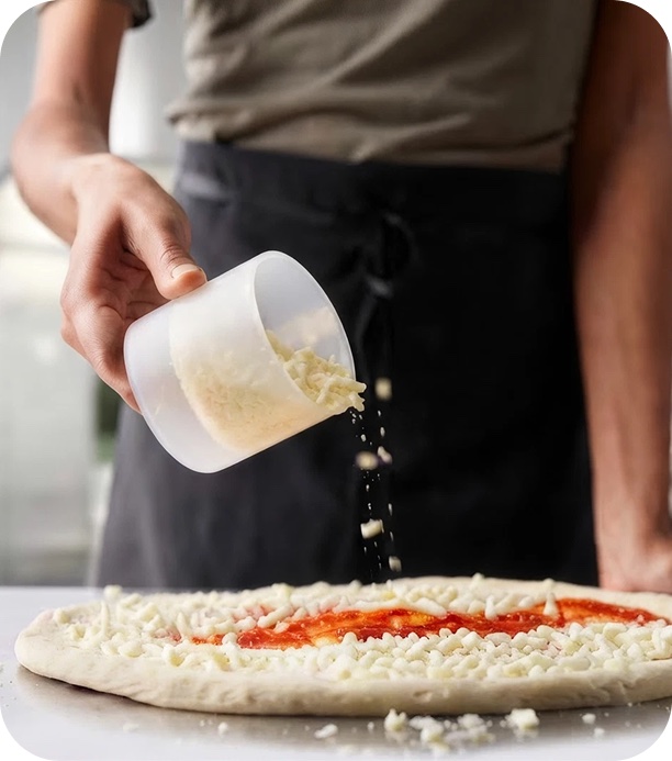 Pizzasauce wird auf den frischen Teig gegeben